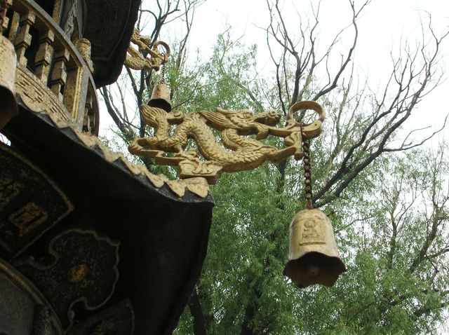 Драконы с колокольчиками, отгоняющими злых духов, на крыше пагоды в буддийском храме города Харбин