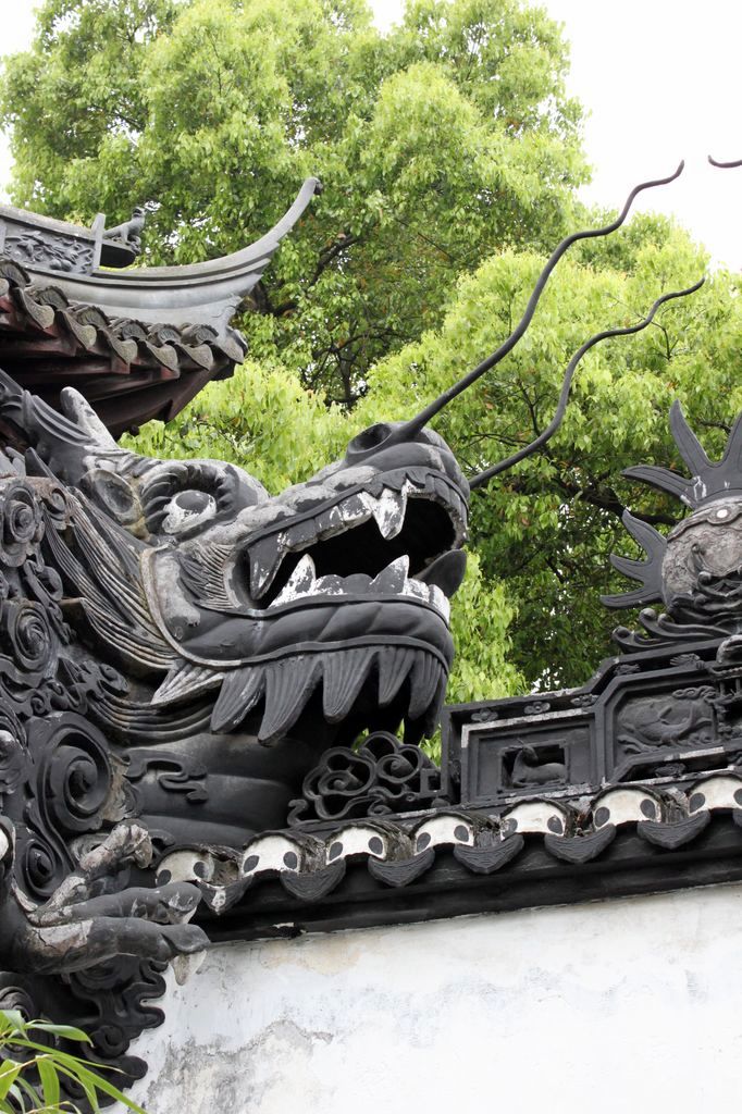 Голова дракона на крыше павильона в парке Юй Юань